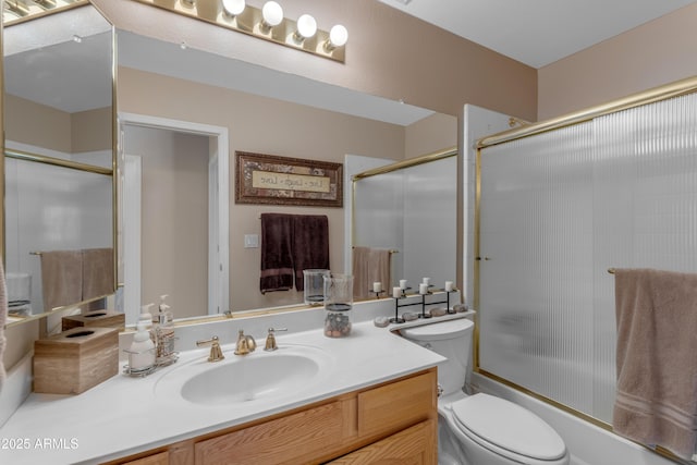 full bath featuring vanity, toilet, and bath / shower combo with glass door