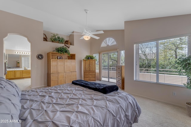 bedroom featuring light carpet, baseboards, arched walkways, and vaulted ceiling