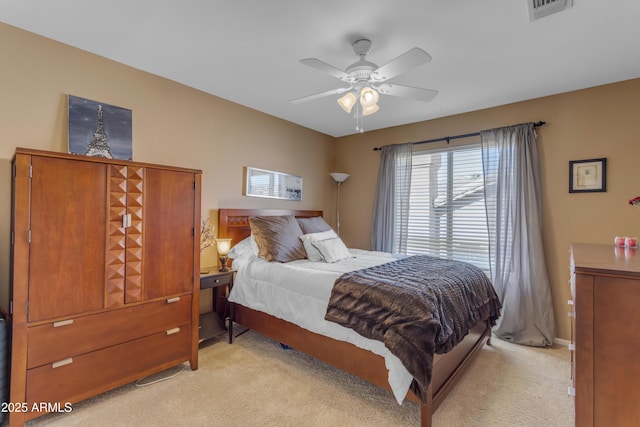 bedroom featuring light carpet, visible vents, and a ceiling fan