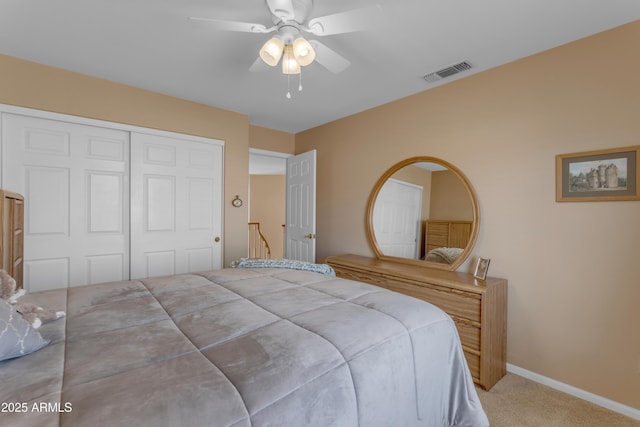 bedroom featuring ceiling fan, light colored carpet, visible vents, baseboards, and a closet