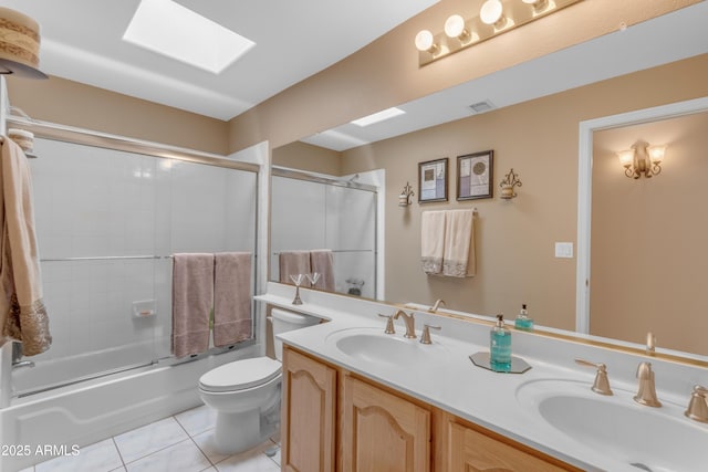 bathroom with tile patterned flooring, a skylight, a sink, and double vanity