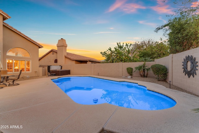 pool at dusk with a fenced backyard, a patio, and a hot tub