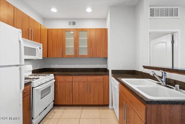 kitchen featuring kitchen peninsula, sink, light tile patterned flooring, and white appliances