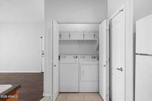 clothes washing area featuring washer and dryer and light tile patterned floors