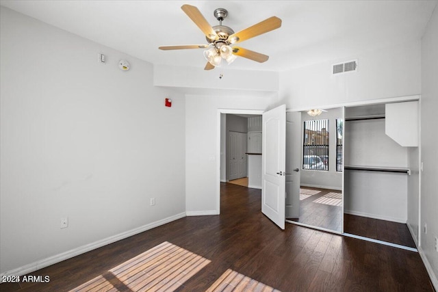 unfurnished bedroom with dark hardwood / wood-style flooring, a closet, and ceiling fan