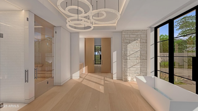 interior space with hardwood / wood-style flooring, plenty of natural light, and a raised ceiling