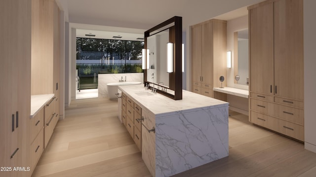 bathroom with hardwood / wood-style flooring, vanity, and a bath