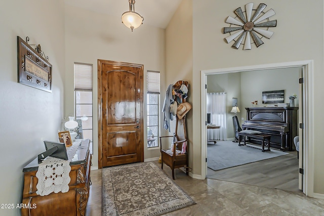 foyer entrance with a towering ceiling and baseboards