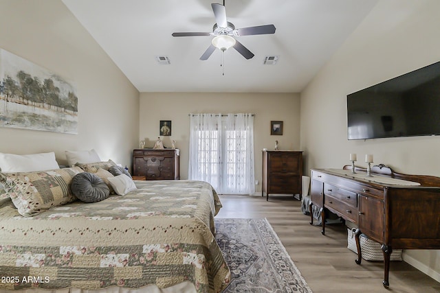 bedroom with lofted ceiling, light wood-type flooring, visible vents, and a ceiling fan