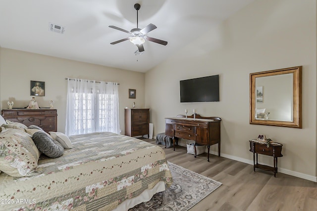 bedroom featuring light wood-style flooring, a ceiling fan, visible vents, vaulted ceiling, and baseboards