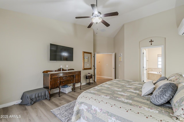 bedroom with baseboards, ensuite bath, ceiling fan, wood finished floors, and high vaulted ceiling