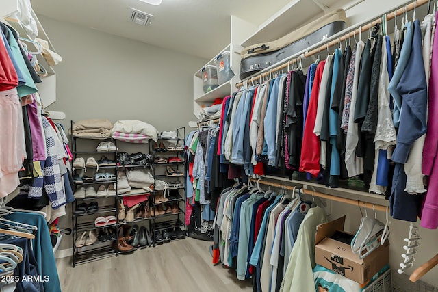 walk in closet with visible vents and wood finished floors