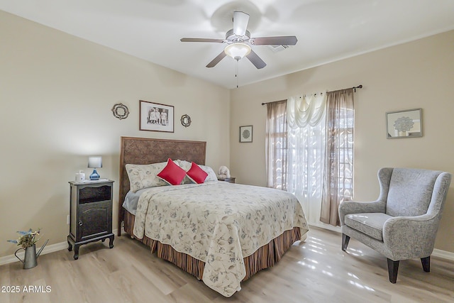 bedroom featuring ceiling fan, light wood-style flooring, and baseboards