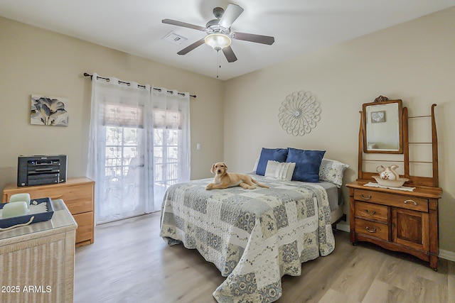 bedroom with light wood-style floors, access to outside, visible vents, and a ceiling fan