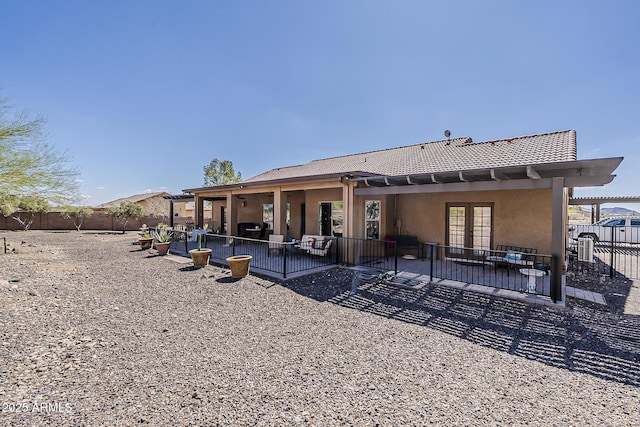 rear view of property with a patio, french doors, a fenced backyard, and stucco siding