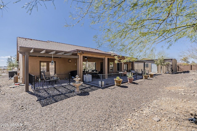 back of property featuring a patio area, a tiled roof, and stucco siding