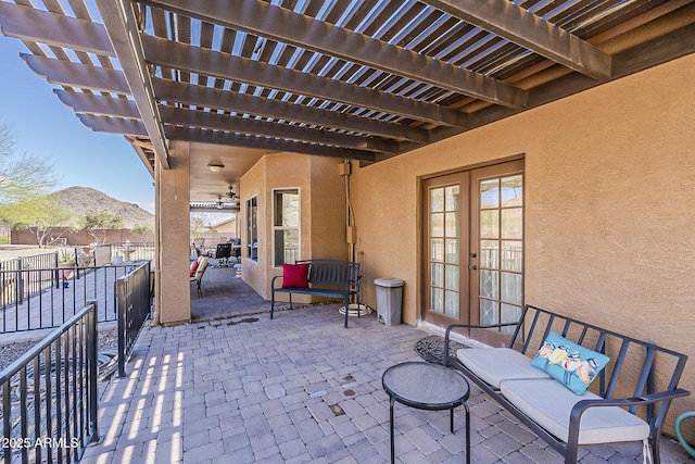 view of patio featuring fence, a mountain view, a pergola, and french doors