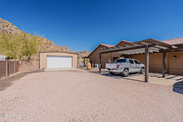 exterior space featuring a garage, fence, and a mountain view