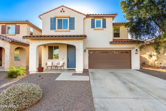 mediterranean / spanish-style home featuring a garage and covered porch