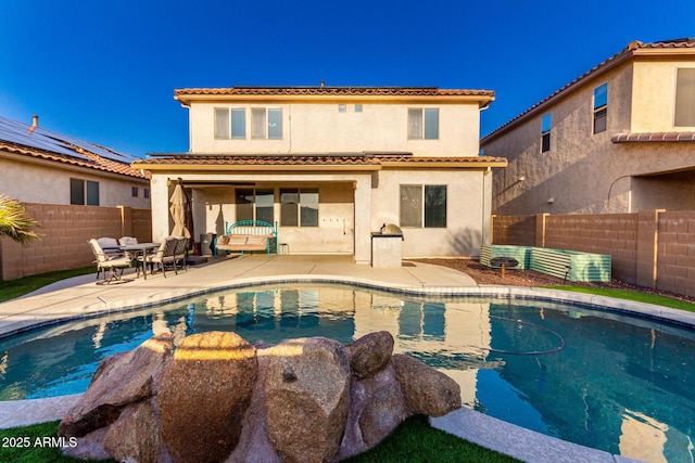 back of house featuring a fenced in pool and a patio