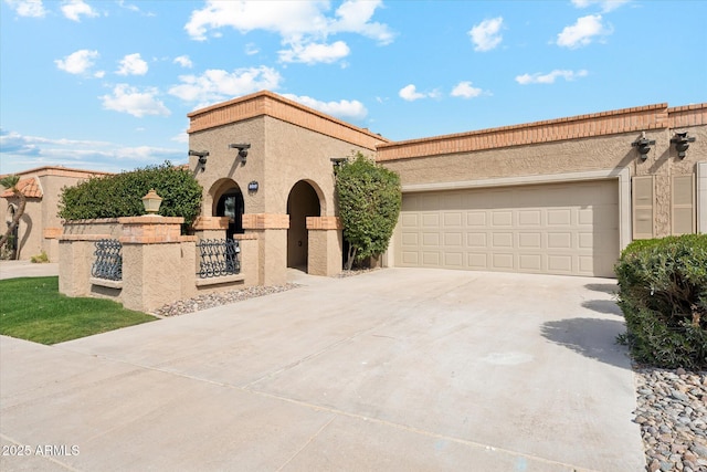 mediterranean / spanish-style home featuring driveway, a garage, and stucco siding