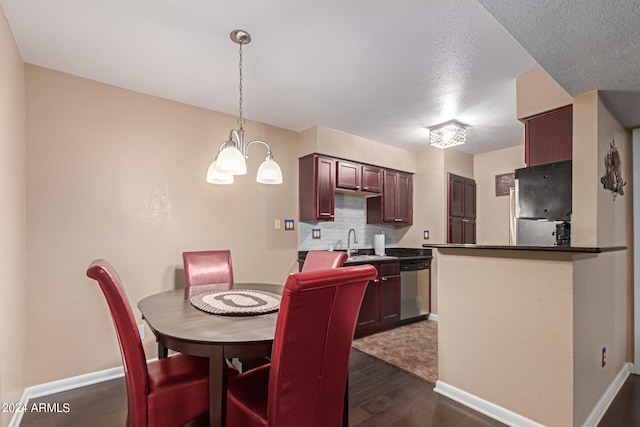 dining room featuring a notable chandelier, sink, dark hardwood / wood-style flooring, and a textured ceiling