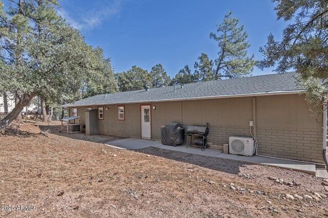 4090 N Cherri Lynn Dr, Pine, AZ 85544 - back of property with a patio, a cooling unit, a shingled roof, and brick siding