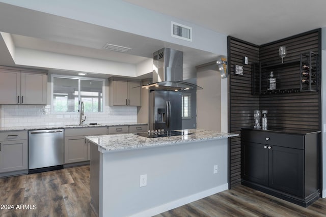 kitchen with appliances with stainless steel finishes, backsplash, island range hood, and sink