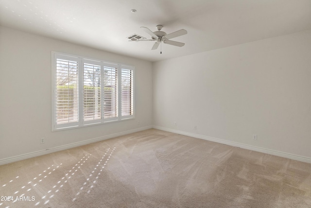 carpeted spare room featuring ceiling fan