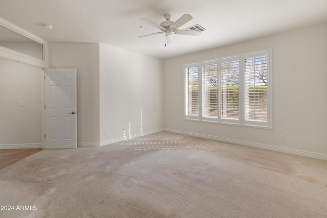 carpeted spare room featuring ceiling fan