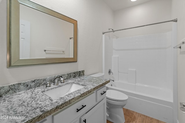 full bathroom with hardwood / wood-style floors, vanity, shower / bath combination, and toilet