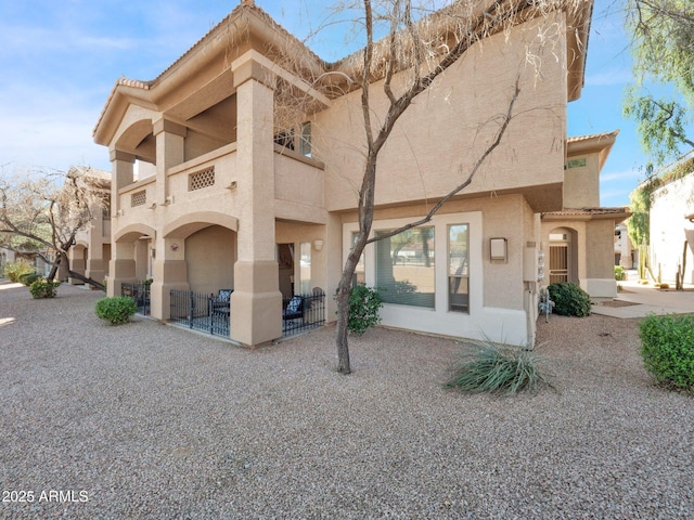 14000 N 94th St Unit 1008, Scottsdale, AZ 85260 - back of property featuring a balcony, a tiled roof, and stucco siding