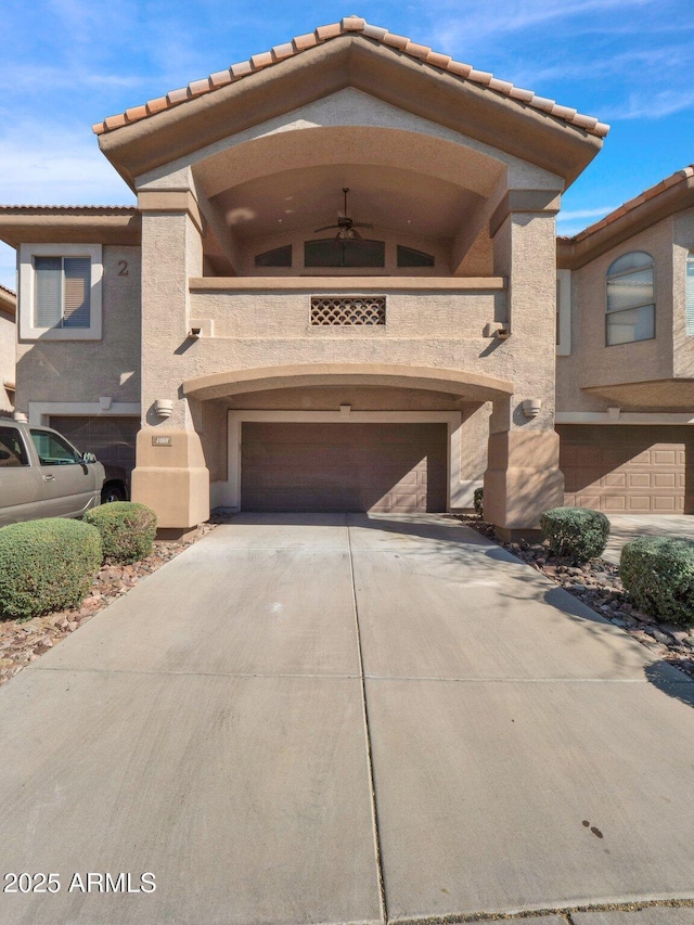 14000 N 94th St Unit 1008, Scottsdale, AZ 85260 - multi unit property featuring a tiled roof, driveway, a garage, a ceiling fan, and stucco siding