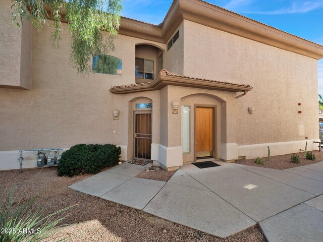 14000 N 94th St Unit 1008, Scottsdale, AZ 85260 - view of exterior entry featuring a tile roof and stucco siding