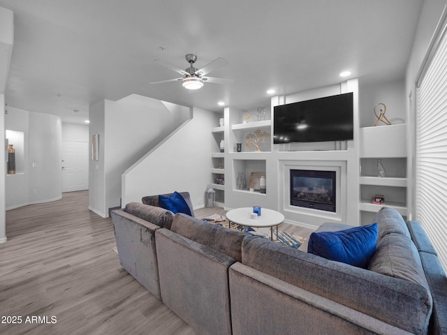 14000 N 94th St Unit 1008, Scottsdale, AZ 85260 - living room with built in shelves, light wood finished floors, baseboards, and ceiling fan