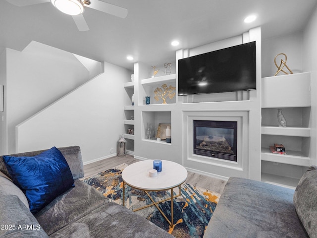 14000 N 94th St Unit 1008, Scottsdale, AZ 85260 - living room with wood finished floors, a glass covered fireplace, ceiling fan, baseboards, and recessed lighting