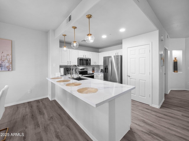 14000 N 94th St Unit 1008, Scottsdale, AZ 85260 - kitchen with dark wood-style floors, baseboards, a peninsula, appliances with stainless steel finishes, and white cabinetry