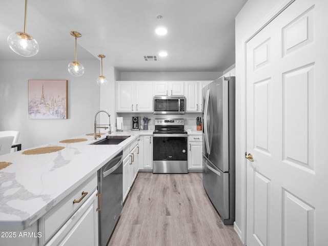 14000 N 94th St Unit 1008, Scottsdale, AZ 85260 - kitchen featuring a sink, white cabinetry, light wood-style flooring, a peninsula, and appliances with stainless steel finishes
