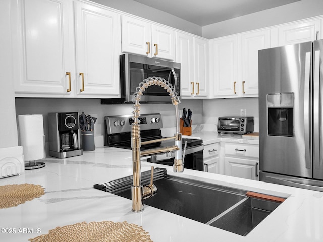 14000 N 94th St Unit 1008, Scottsdale, AZ 85260 - kitchen with light stone counters, appliances with stainless steel finishes, a toaster, and white cabinetry