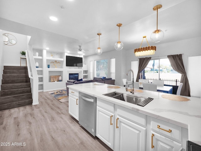 14000 N 94th St Unit 1008, Scottsdale, AZ 85260 - kitchen with a sink, a glass covered fireplace, white cabinetry, ceiling fan, and dishwasher