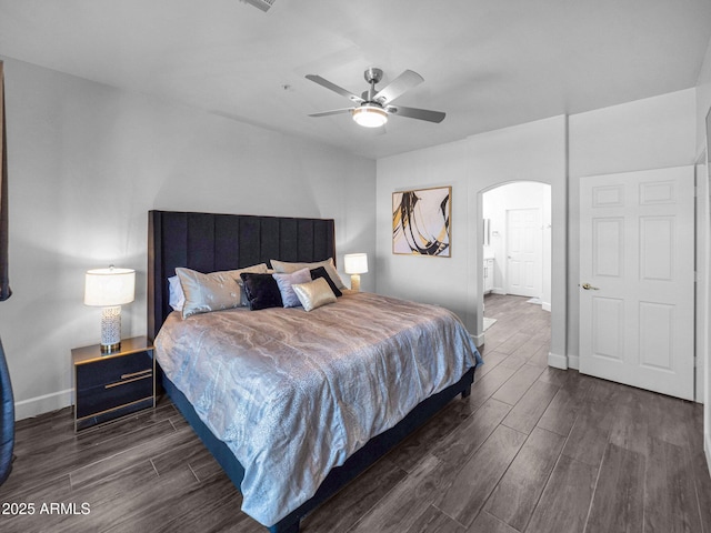 14000 N 94th St Unit 1008, Scottsdale, AZ 85260 - bedroom with a ceiling fan, baseboards, arched walkways, and dark wood-style flooring