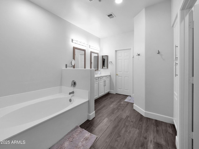 14000 N 94th St Unit 1008, Scottsdale, AZ 85260 - bathroom with a garden tub, wood finished floors, vanity, baseboards, and visible vents