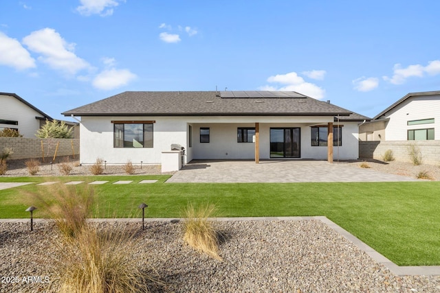 rear view of house featuring a lawn and a patio