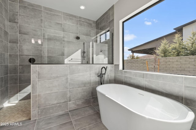 bathroom with separate shower and tub and tile walls