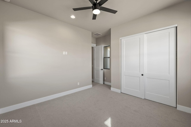 unfurnished bedroom with light carpet, a closet, and ceiling fan