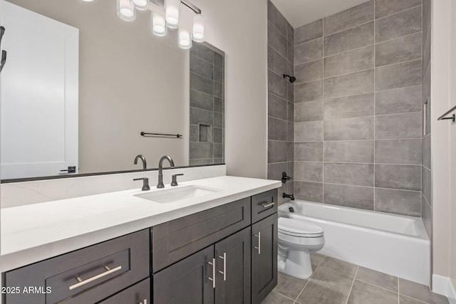 full bathroom featuring tile patterned flooring, vanity, tiled shower / bath combo, and toilet