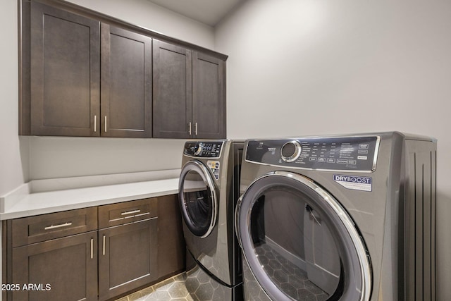 washroom featuring cabinets and washing machine and clothes dryer