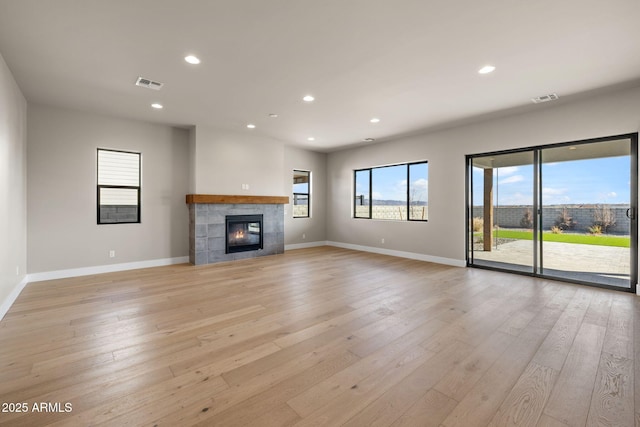 unfurnished living room with a fireplace and light hardwood / wood-style floors