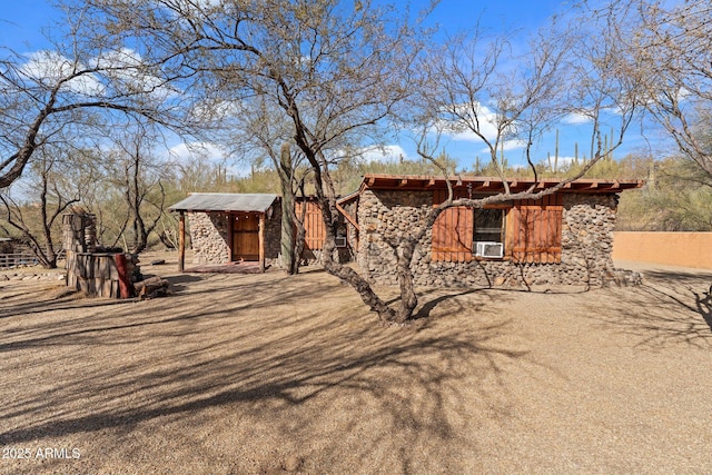 view of front facade with cooling unit and a storage shed