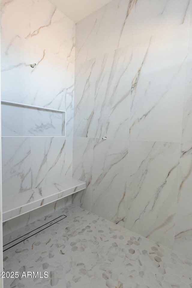 bathroom with a marble finish shower